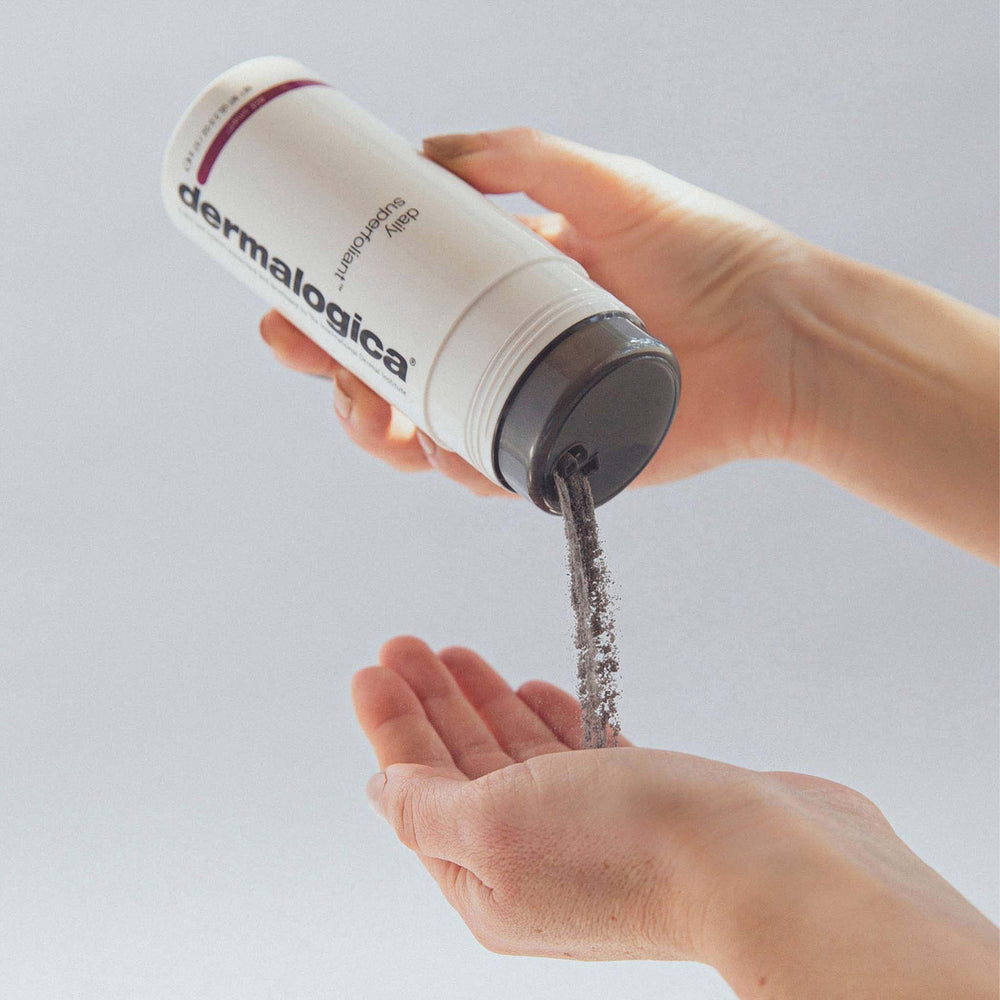 Dermalogica daily superfoliant being poured from a container into a hand against a light gray background