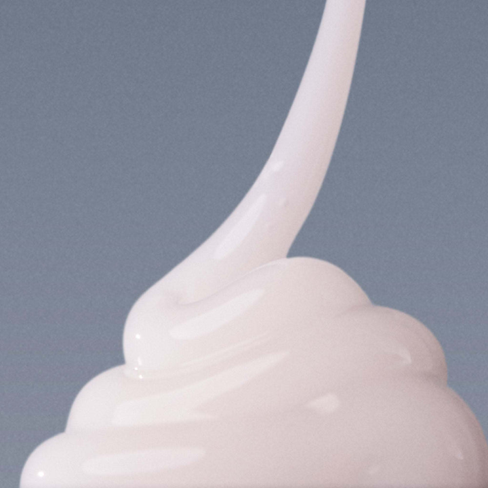White cream being piped onto a gray background